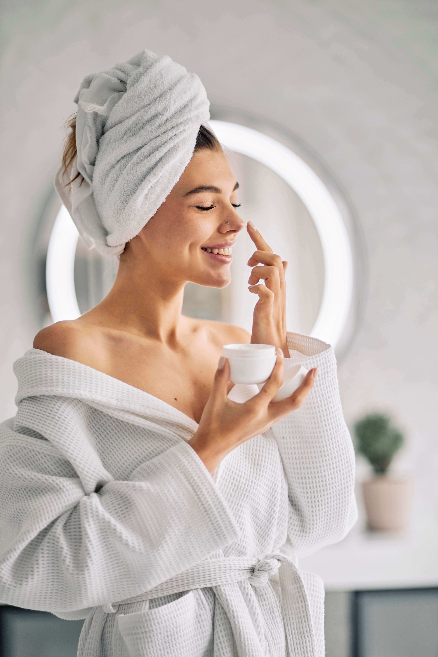O femeie care isi face rutina de ingrijire cu o crema pe baza de extract de melc